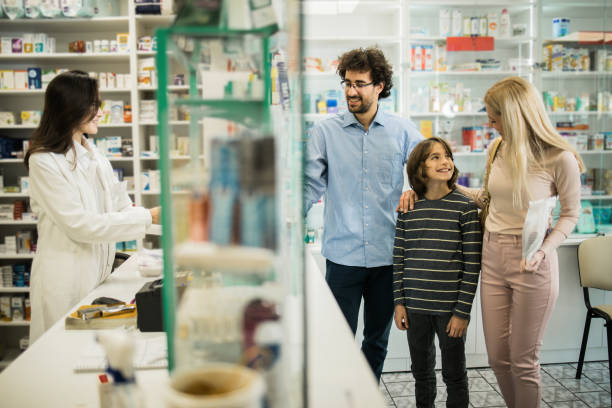 istock Female pharmacist working with a young family 1451072104