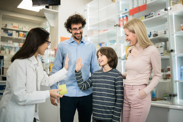 istock Boy throwing a high-five to a pharmacist during a purchase with his parents 1451072280
