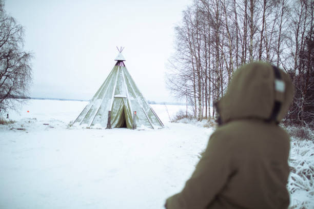 una donna irriconoscibile guarda nel wigwam - rear view winter blizzard nordic countries foto e immagini stock