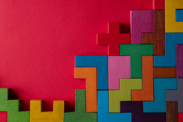 istock Top view on colorful wooden blocks folding on red background 1451073820
