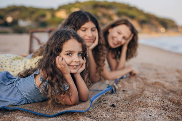 istock Mom and daughters lying on the beach 1451074557