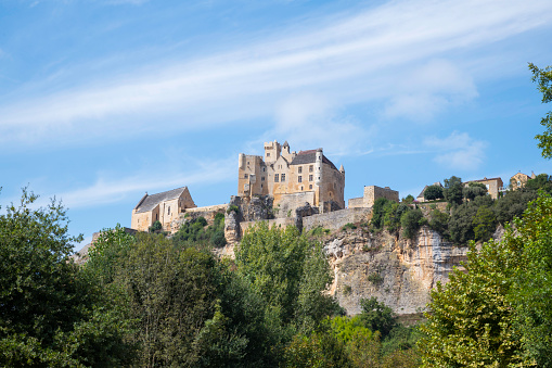 The Chateau de Beynac towers over the town of Beynac which clings to the rocks in a bend of the Dordogne river, France