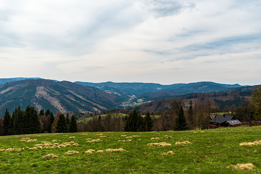 Lomna valley with hills around from Kamenite in Moravskoslezske Beskydy mountains in Czech republic during mostly cloudy springtime day
