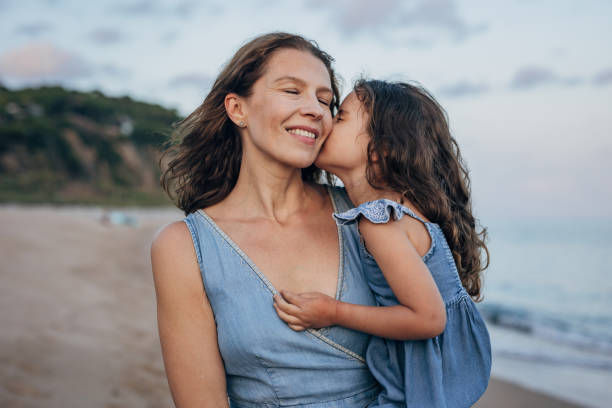 istock Girl kissing her mom 1451076546