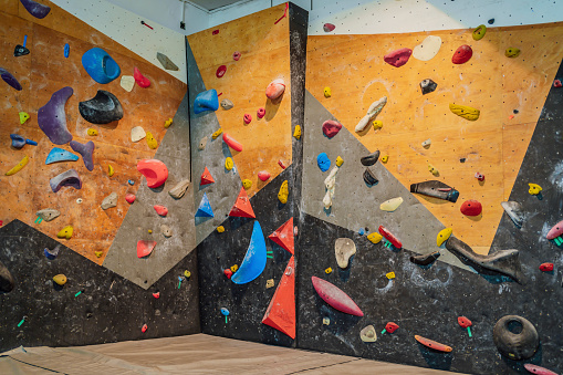 Artificial rock climbing walls with multi-colored holds spread throughout the wall. Indoor rock climbing walls
