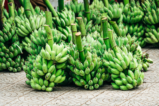 Green bananas for sale at the market\nVietnam