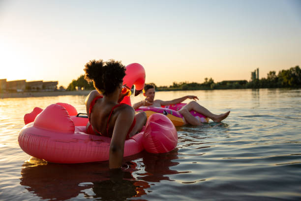 istock Friends relaxing in inflatable rings floating on lake 1451084282
