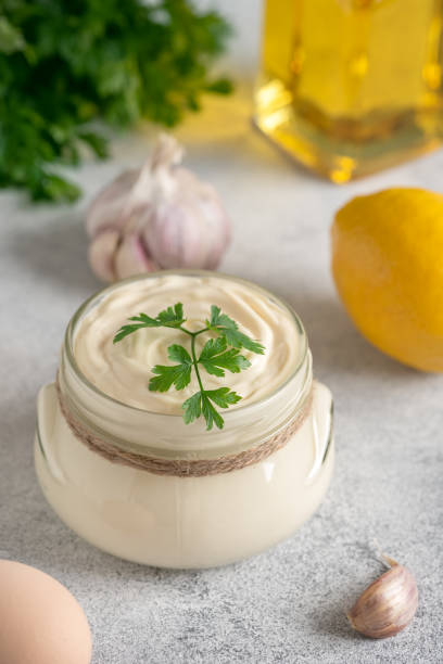 istock Aioli sauce with ingredients on a light gray grunge background. Side view, selective focus, copy space. Homemade mayonnaise. Vertical image. 1451085382