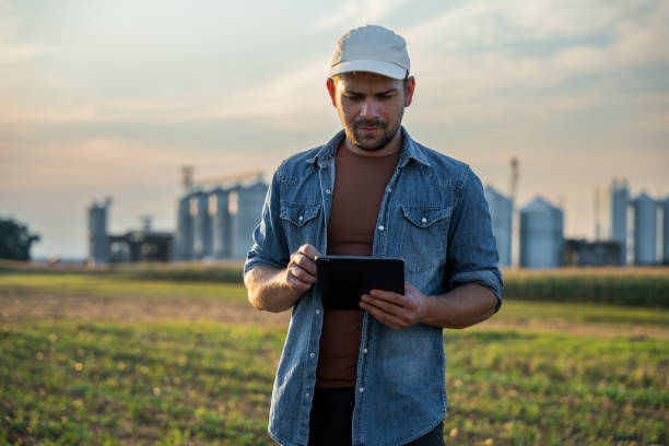 istock Male farmer using digital tablet in field against sky 1451085874
