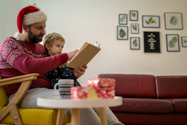 istock Father and cute little toddler boy reading book 1451085908