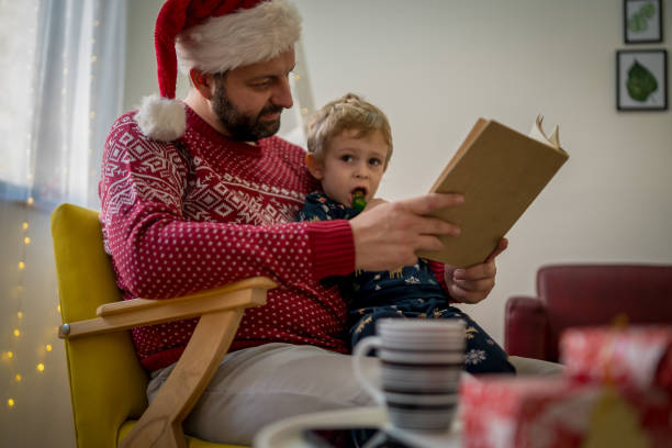 istock Father and cute little toddler boy reading book 1451085963