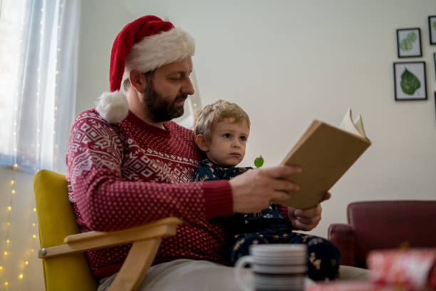 istock Father and cute little toddler boy reading book 1451086043