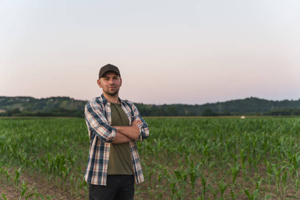 istock Male farmer standing with arms crossed in corn field 1451086734