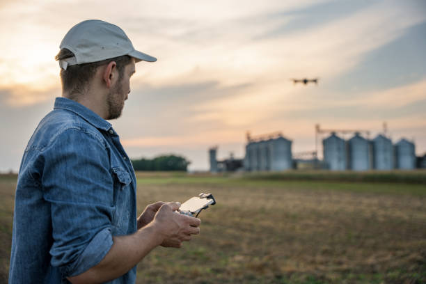 istock Male farmer with remote controller flying drone above farmland 1451087072