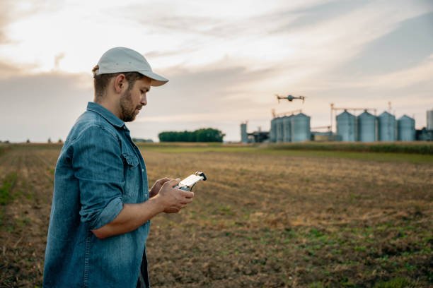 istock Male farmer with remote controller flying drone above farmland 1451087078