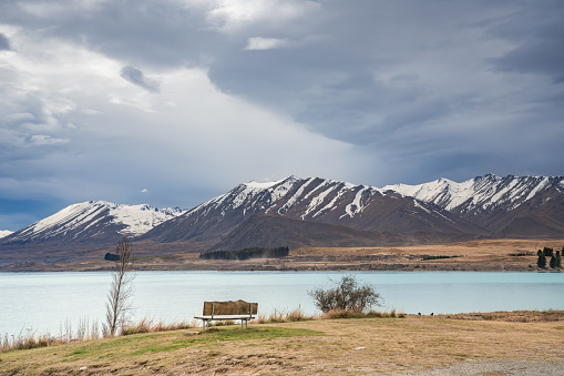 Beautiful view of Lake Tekapo in the morning. Photo taken at winter season with snow capped southern alps at the background. Picnic bench with best view of the lake.