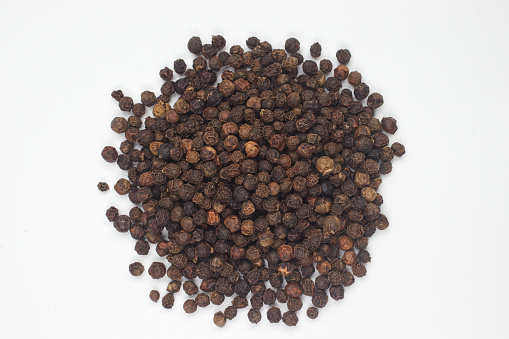 Black pepper placed on white background