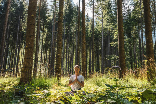 istock Yogi meditating in prayer position amidst green plants and trees 1451090635