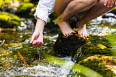 istock Close-up of woman playing with river water in rainforest 1451090643