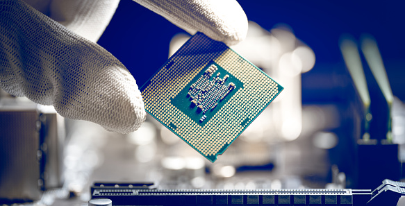 Microprocessor or CPU is held in the hand of a laboratory technician. Central Processing Unit, CPU socket of the computer motherboard, hardware technology, semiconductor chipset, Repairman computer,