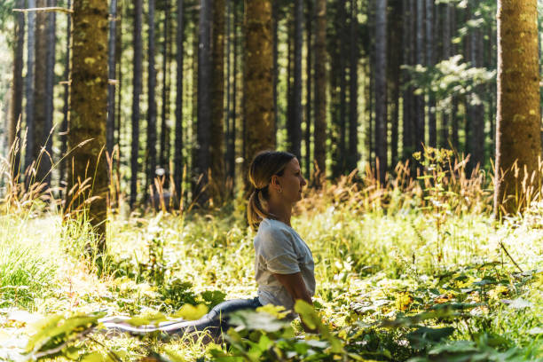 istock Focused woman practicing cobra pose amidst plants in woodland 1451091726