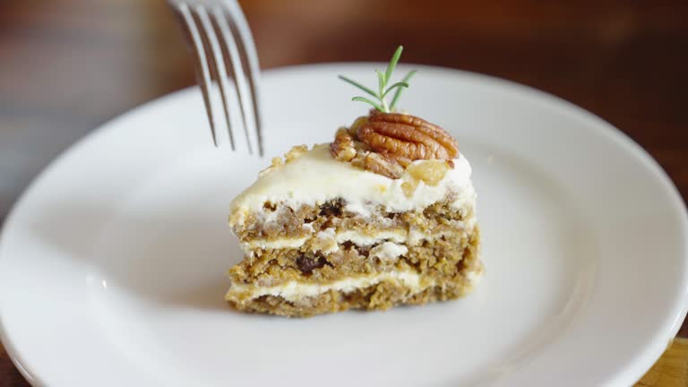 A slice of pecan butter cake was eaten with a fork on a white plate