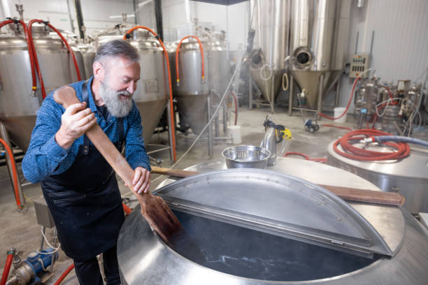 istock Brewery worker stirring fresh beer in a tank 1451094543