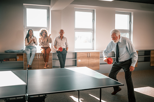 Business colleagues are playing table tenis at work