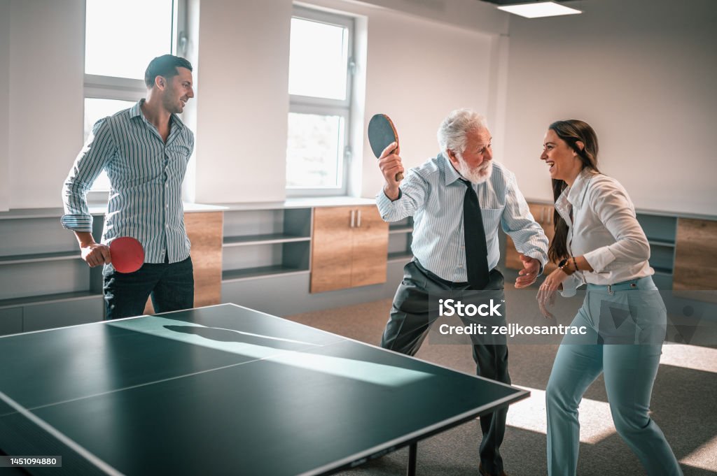 Business colleagues are playing table tenis at work Adult Stock Photo