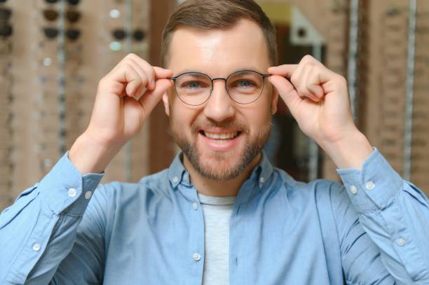 istock Man is choosing glasses in optics store. 1451097501