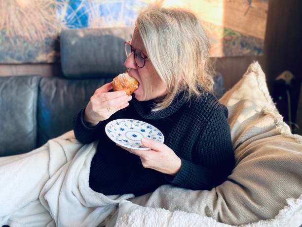 istock Woman Eating an Oliebol 1451098174