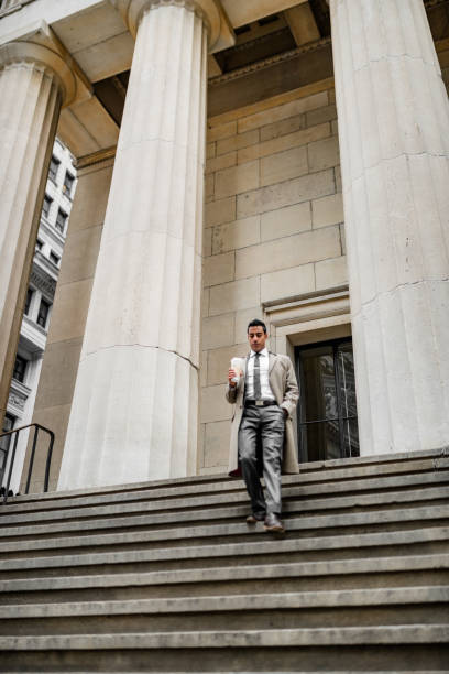 istock business man walking down from steps in wall street 1451098983