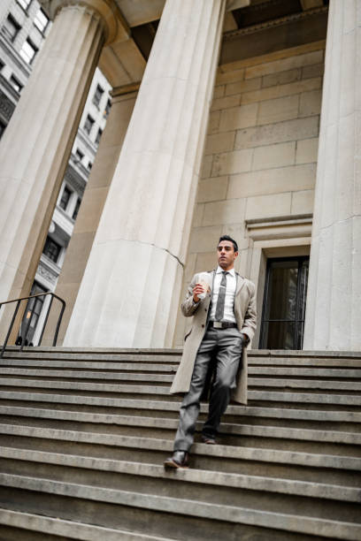 istock business man walking down from steps in wall street 1451099004