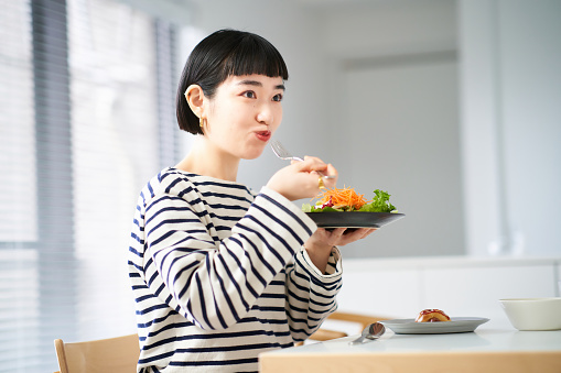 Mujer comiendo en casa cenando photo
