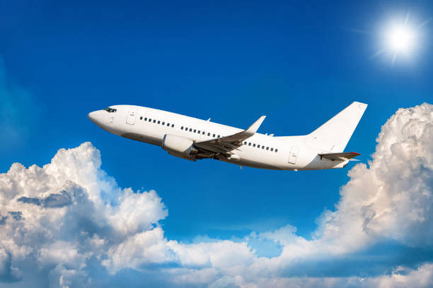 istock White passenger jetliner flying in the air above scenic clouds 1451103012