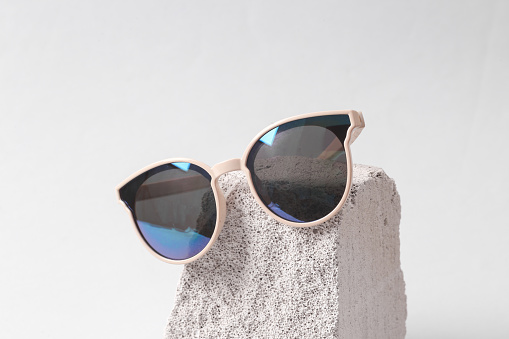 Minimalistic scene with sunglasses on the stone. Fashion concept. Abstract composition