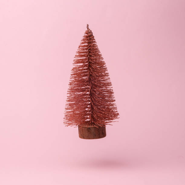 istock Decorative Christmas tree flying in antigravity on pink background with shadow. Levitation object in the air. Creative minimal layout 1451103972