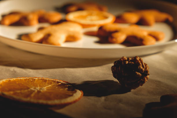 istock Gingerbread men with orange and nuts on baking paper . Christmas wallpaper. 1451104237