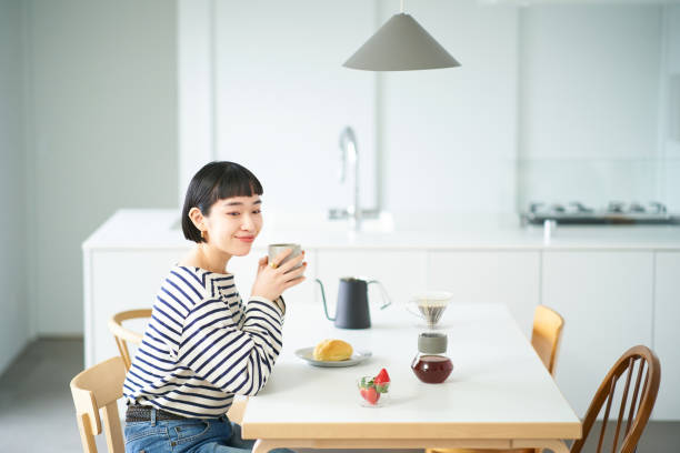 mujer tomando café en la habitación - coffee break home interior cafe coffee fotografías e imágenes de stock