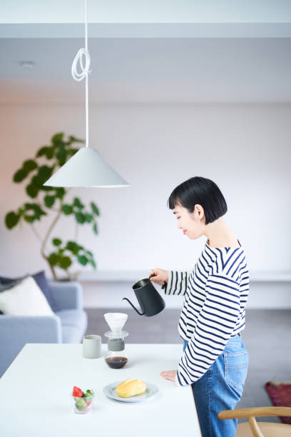 istock woman brewing coffee in her room 1451105923