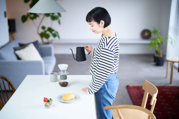 istock woman brewing coffee in her room 1451105978