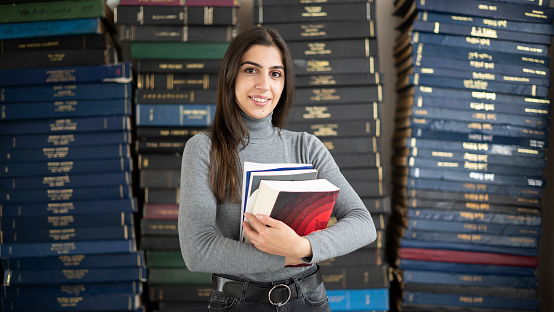 University student, beautiful girl smiling looking at camera in old library