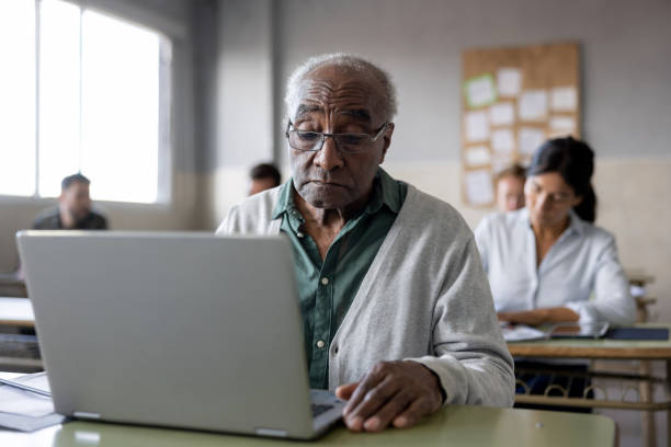 istock Senior man in an IT class at college using a laptop computer 1451106845