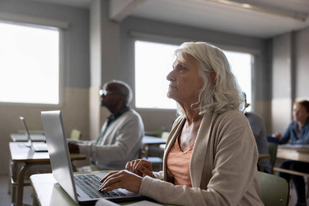 istock Senior woman taking a class in college and using a laptop computer 1451106870