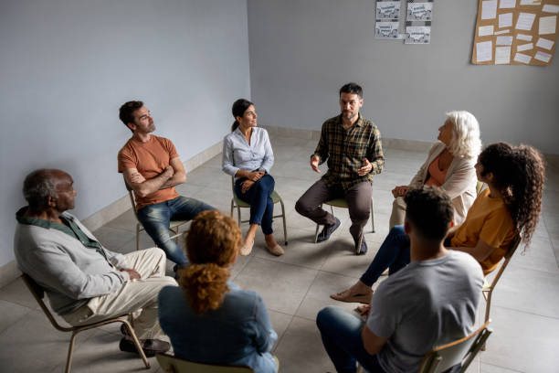 istock Man talking with people in a group therapy session 1451107502