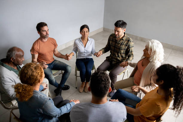 istock People holding hands in a group therapy session 1451107507
