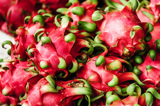 Assortment of tropical exotic fruits: dragon fruit, bananas, passion fruit, longan, rambutan on a wooden background