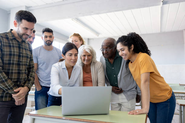 happy group of students in a computer class with their teacher - night school imagens e fotografias de stock