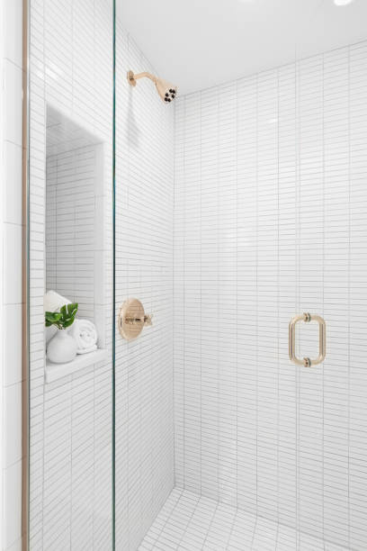 istock A shower with white subway tiles and gold faucet. 1451110064