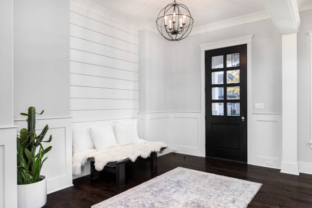 a beautiful foyer with dark wood floors and a ship lap wall behind a bench. - corridor entrance hall floor hardwood imagens e fotografias de stock